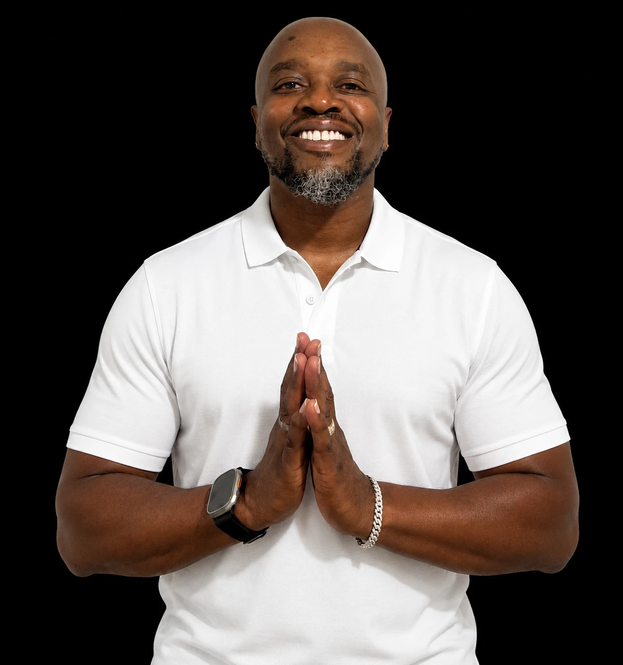 John Louden smiling in a white polo, hands together, against a black background