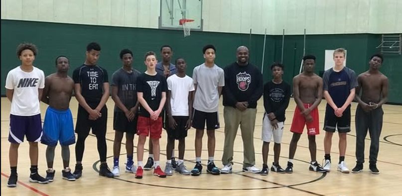 John Louden standing with a group of young athletes in a gym