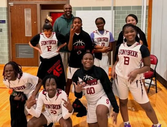 John Louden with a smiling Stonybrook youth basketball team